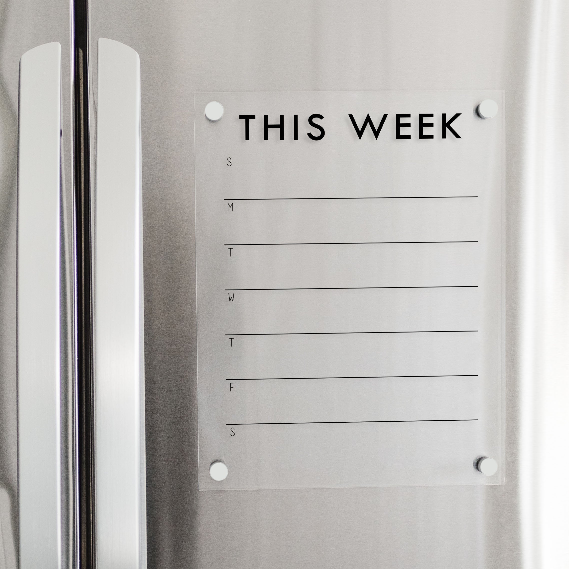 A Dry-erase weekly calender made of acrylic hanging on the fridge