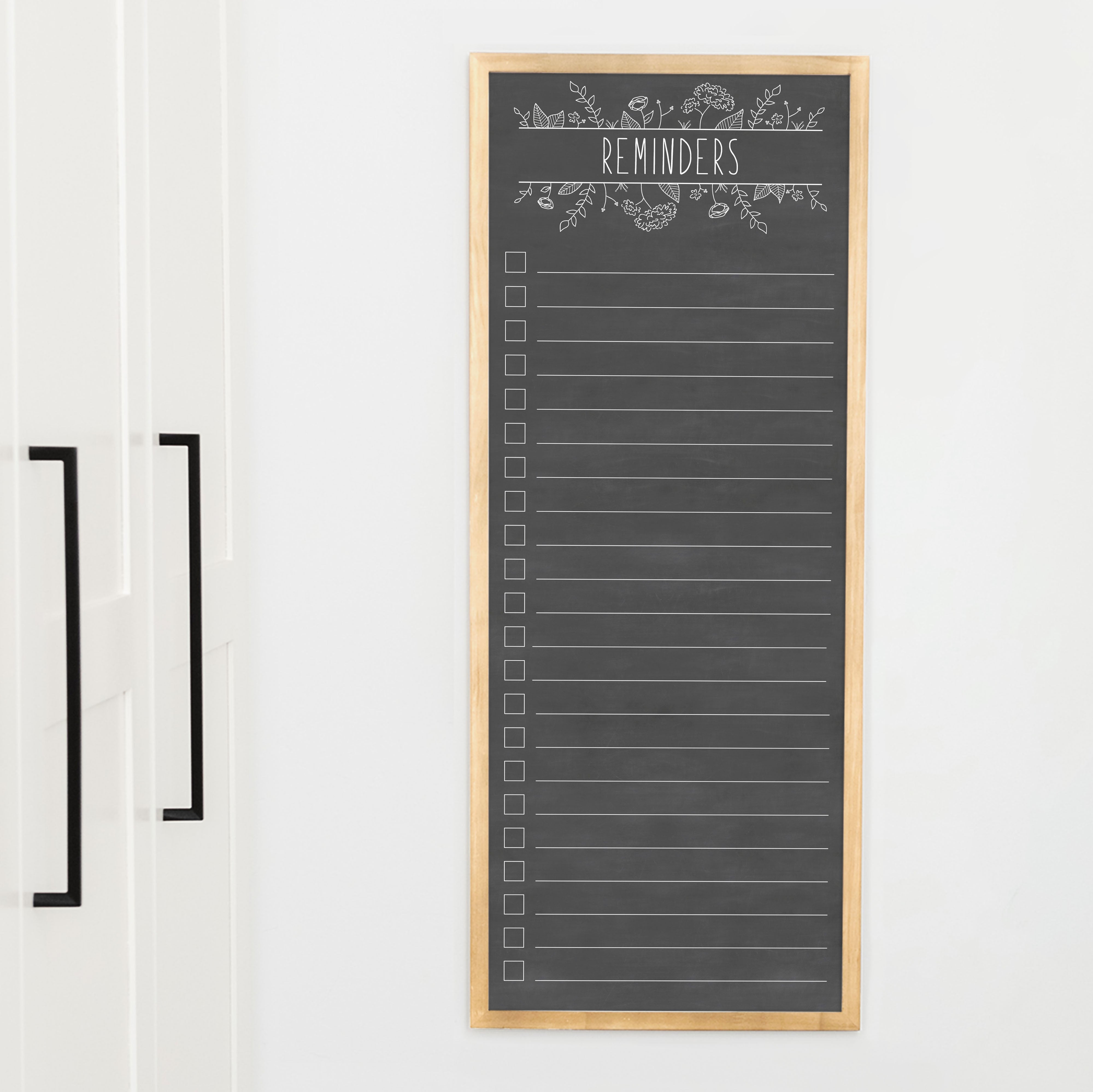 A framed dry-erase to do list with a chalkboard look hanging on the wall