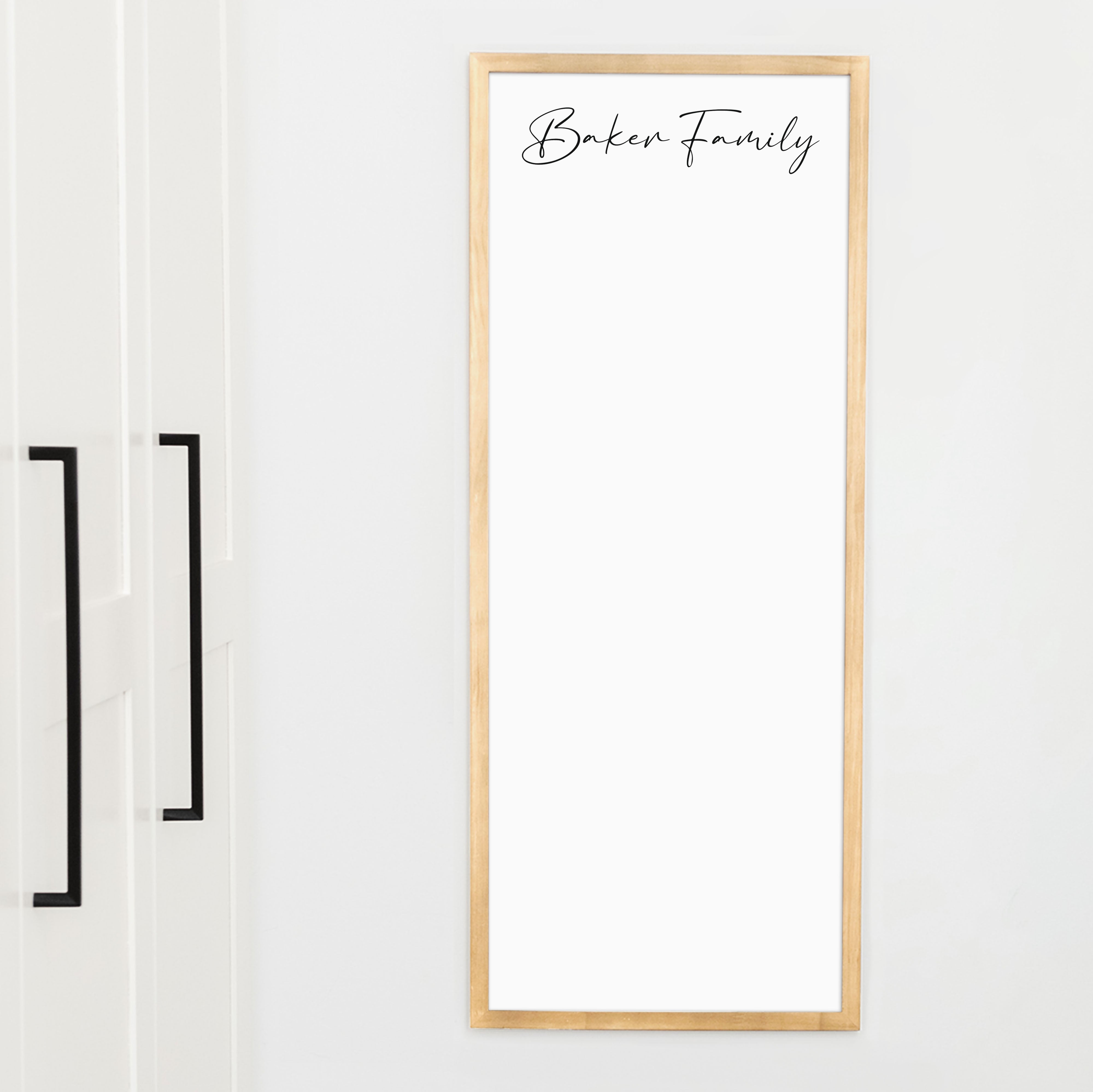 A framed whiteboard calendar with a two month design format hanging on the wall