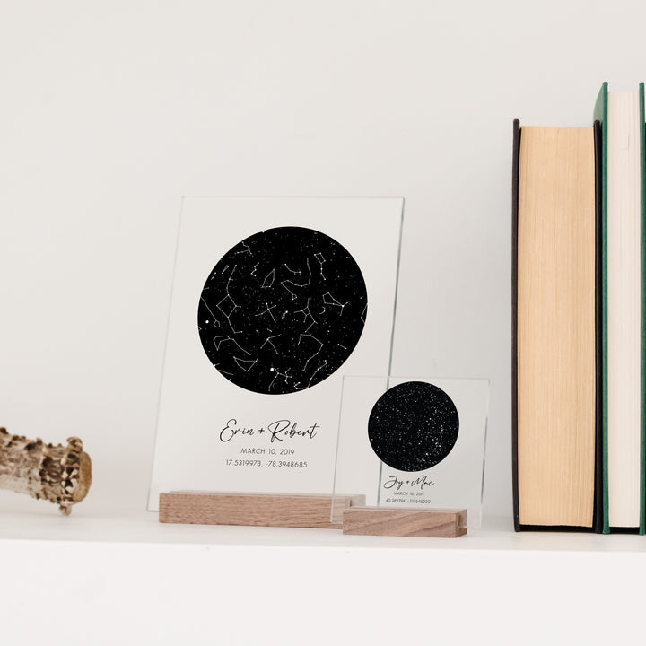 Two custom star chart anniversary gift signs on a bookshelf.