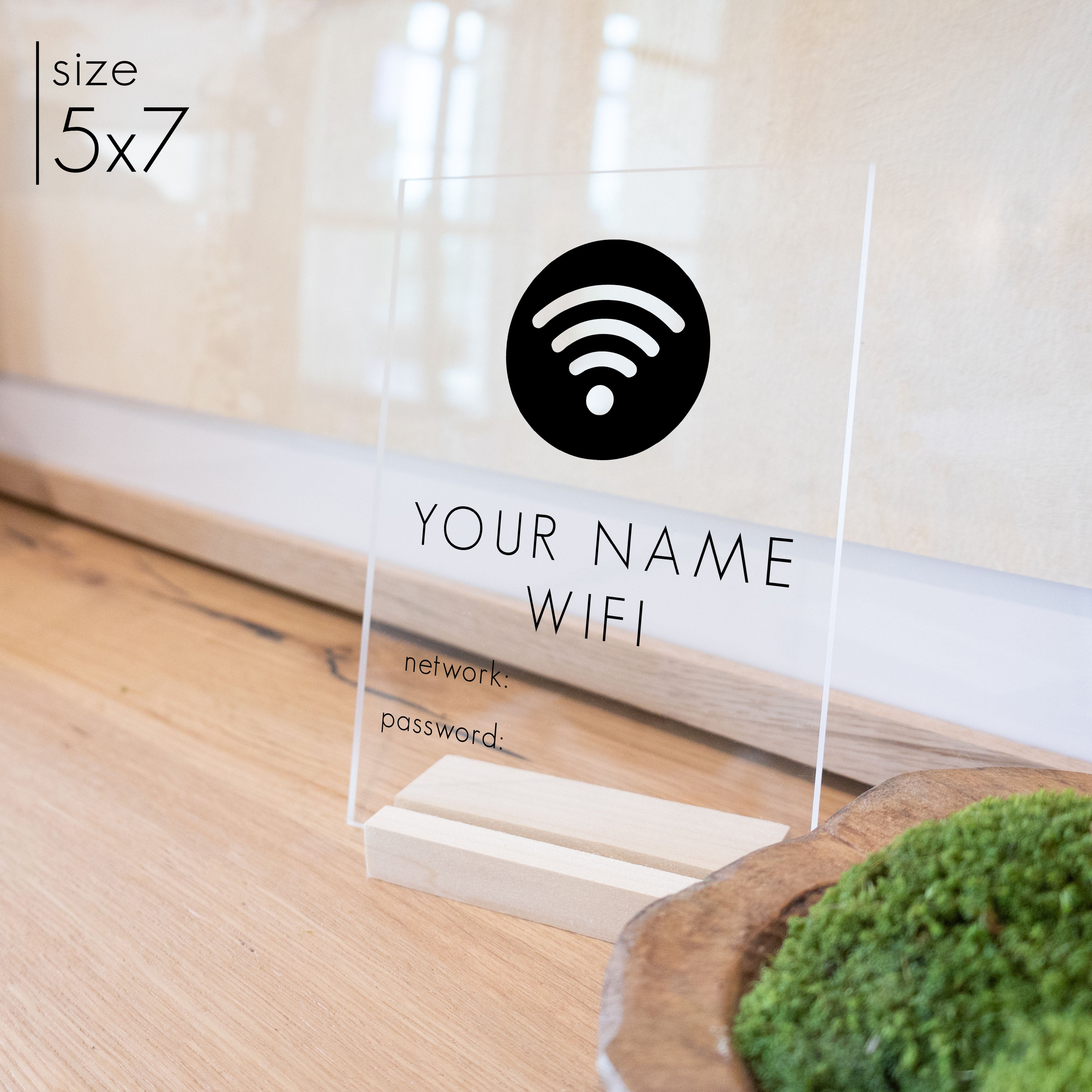 A 5x7 wifi password sign on a blonde stand on an entryway table