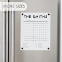A Dry-erase acrylic chore chart hanging on the fridge