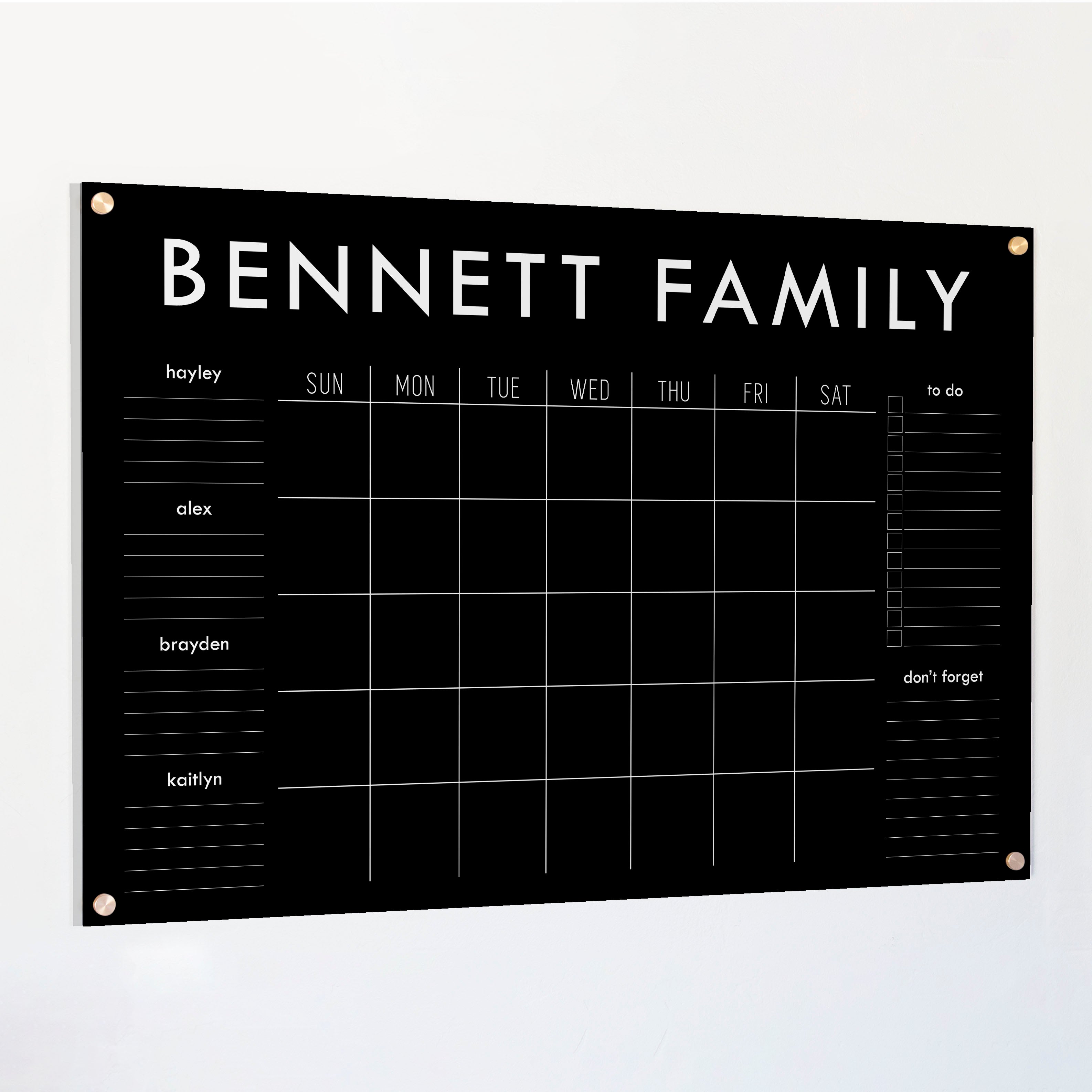 A Dry-erase family command center made of acrylic hanging on the wall